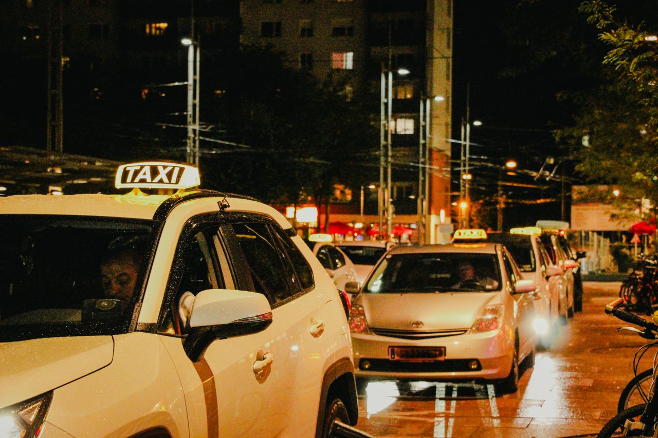 Home Taxis lined up under streetlights in Salzburg, Austria, captured at night.