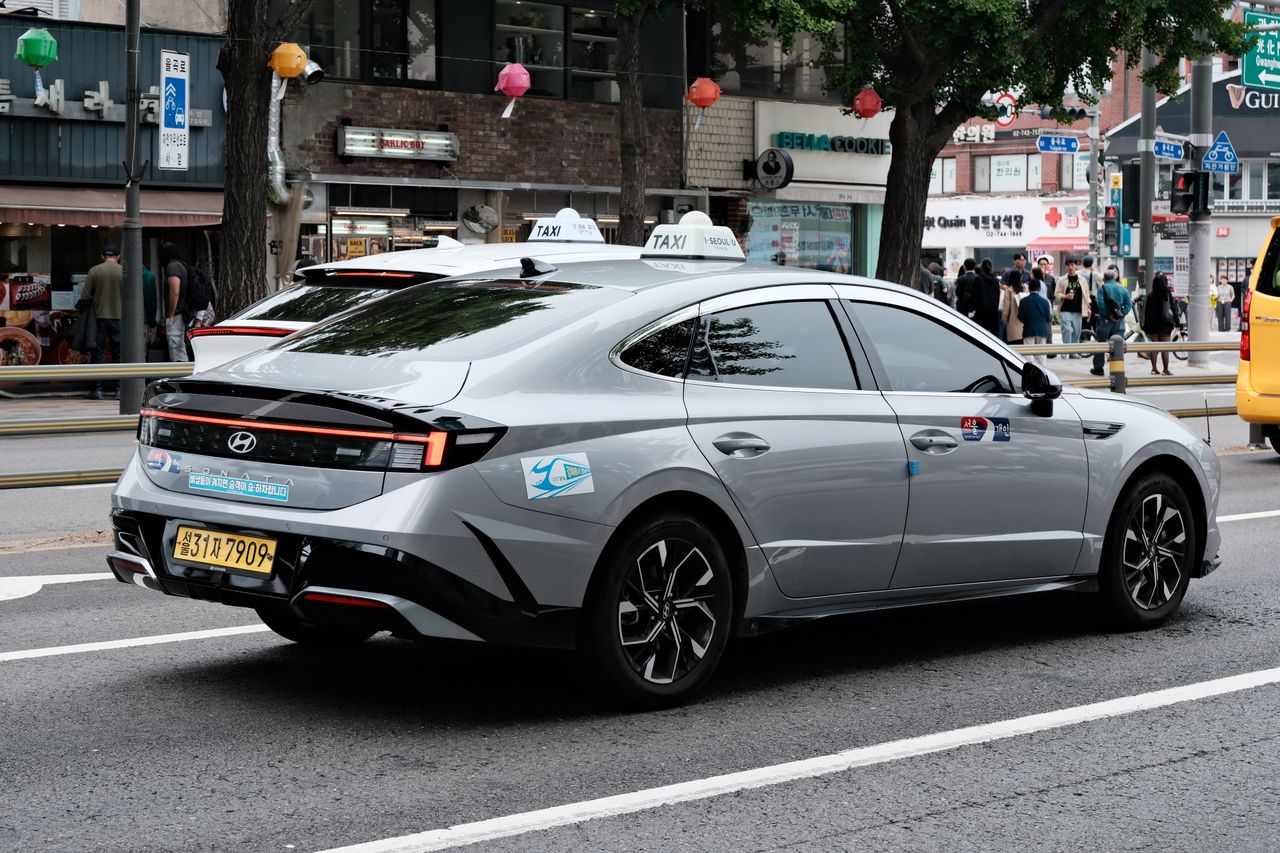Hyundai taxi driving through a bustling street in Seoul, South Korea.